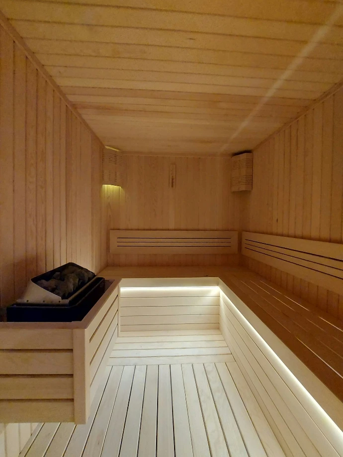 a wooden room with a bench and a light
